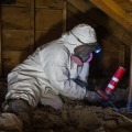 Attic penetration being inspected and air sealed by weatherization technician.
