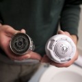 An installer holding two pieces of the low-flow shower head in their hands.