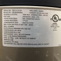 A white nameplate containing text describing specifications for a gray heat pump water heater.