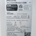 A silver nameplate containing text describing specifications for an off-white mini-split heat pump.