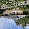 Dark gray and silver photovoltaic panels installed on a gray roof with no shading and lots of sun of a tan home. 