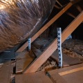 An insulation depth marker secured to attic framing.