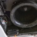 A close up image of a bathroom exhaust fan with the vent grill removed.