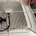 Close up of a bathroom exhaust fan grill equipped with a motion sensor.